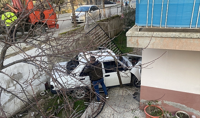 İzmir'de yoldan çıkan otomobil bir apartmanın bahçesine düştü